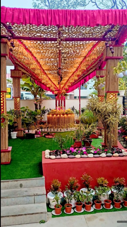 The lawn now — bamboo canopy with coconut shell curtain, raised flower bed, artificial grass, potted plants on steps