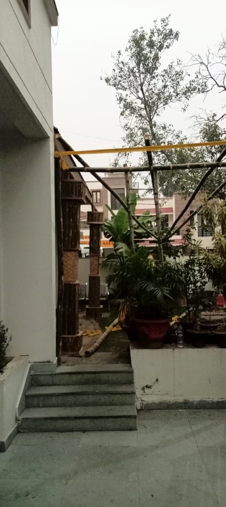 Bamboo and metal canopy frame being erected at the entrance steps
