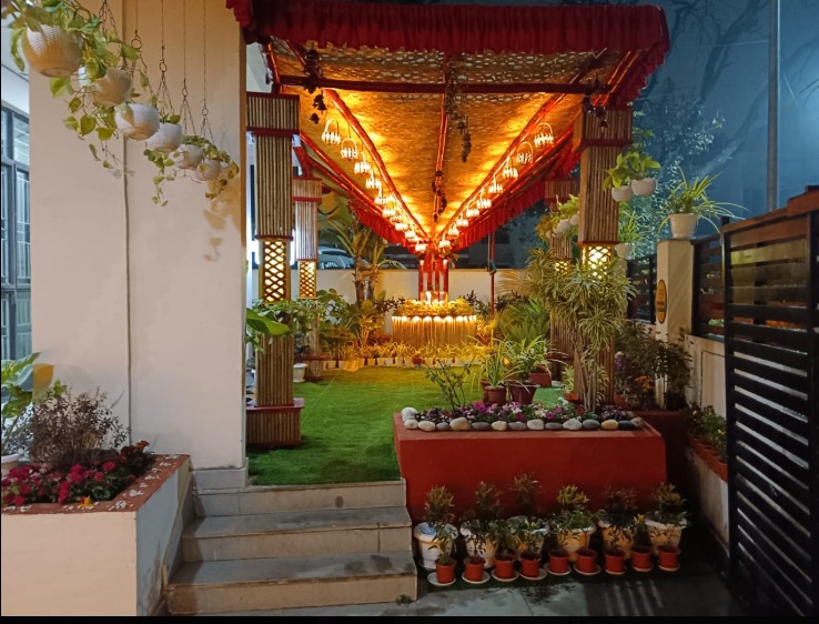 The entrance garden at night, warm Edison bulbs glowing through the bamboo and coconut shell canopy