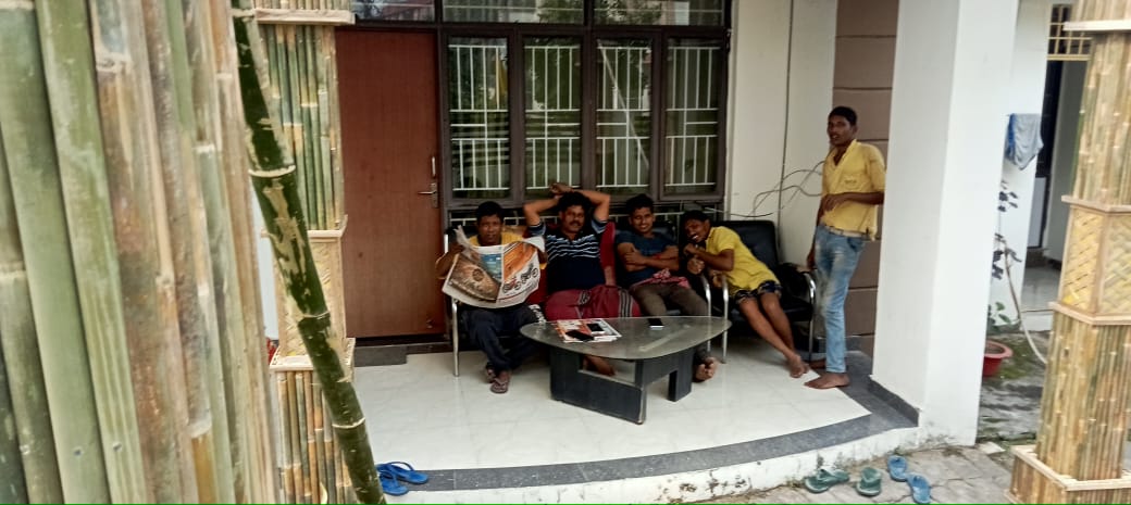 The artisan team taking a break on the veranda between bamboo columns